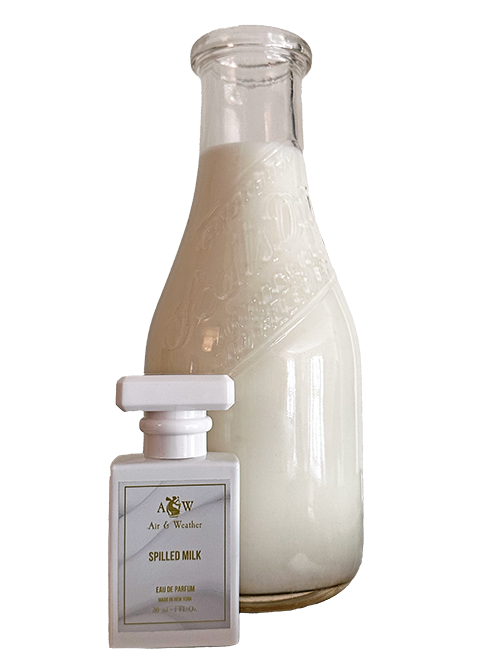 SM.bottle.nobg Air & Weather's Spilled Milk Perfume, 1 oz. bottle sits beside a tall old fashioned glass milk bottle filled with milk.